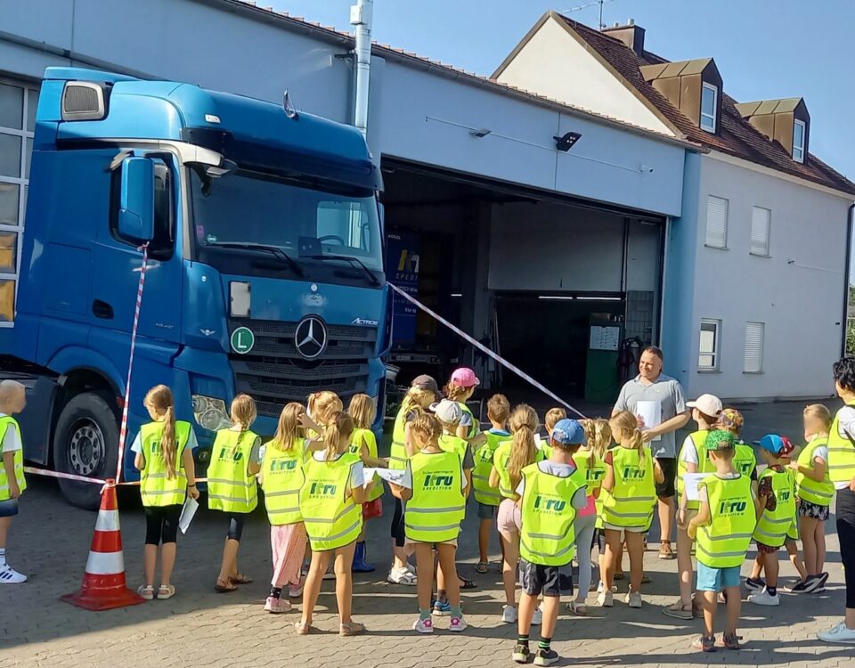 Linder mit KTU Spedition Warnwesten stehen um LKW herum